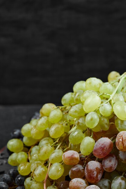 A plate of mixed grapes on dark background. High quality photo