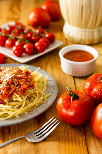 Free photo plate of pasta with fork on wooden table