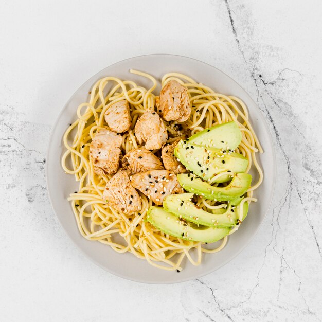 Plate of pasta with meat and avocado