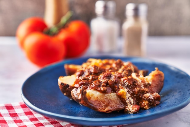 Plate of roasted potatoes with sauce on marble surface