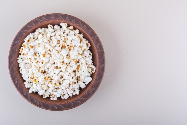 Plate of salted popcorn for movie night on white background. High quality photo