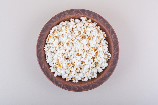 Plate of salted popcorn for movie night on white background. High quality photo