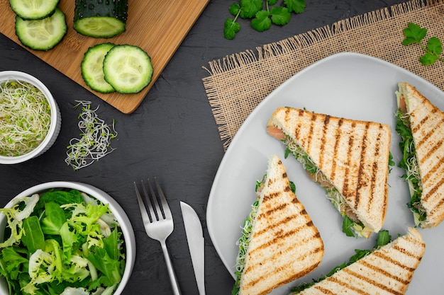 Plate of sandwiches with salad and cucumber