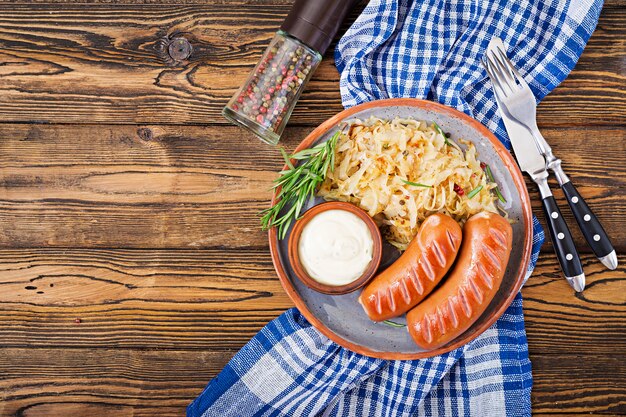 소시지와 소금에 절인 양배추 나무 테이블에 접시. 옥토버 페스트 전통 메뉴. 평평하다. 평면도.