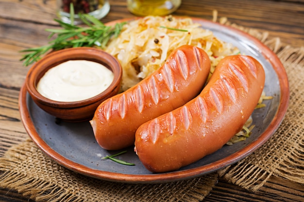 Plate of sausages and sauerkraut on wooden table. Traditional Oktoberfest menu