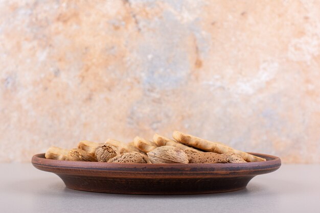 Plate of shelled organic almonds and biscuits on white background. High quality photo