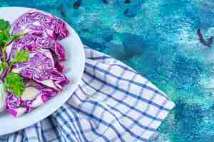 Free photo a plate of sliced cabbage and red cabbage on a towel