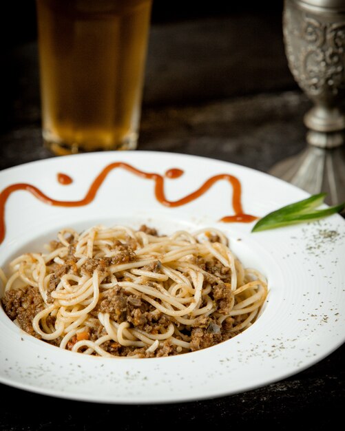 A plate of spaghetti with meat and yellow bell pepper