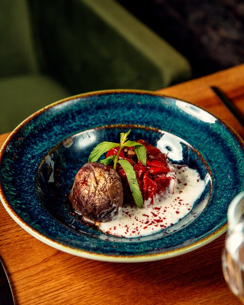 A plate of stuffed tomato dish with roasted potato and yogurt 1