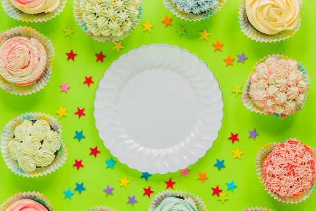 Plate surrounded with cupcakes