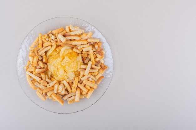 Free photo plate of tasty crispy crackers and chips on white background. high quality photo