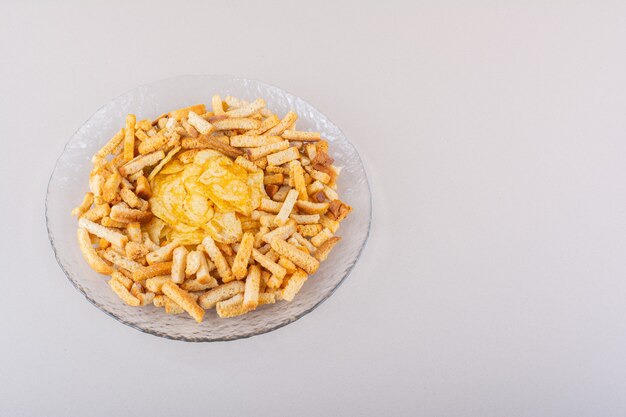 Plate of tasty crispy crackers and chips