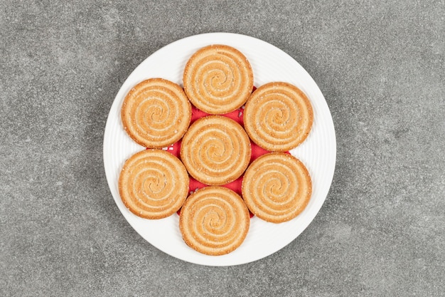 Plate of tasty round biscuits on marble surface