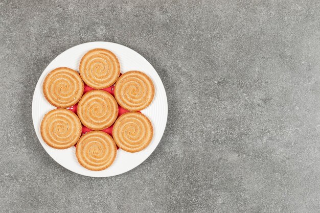 Plate of tasty round biscuits on marble surface