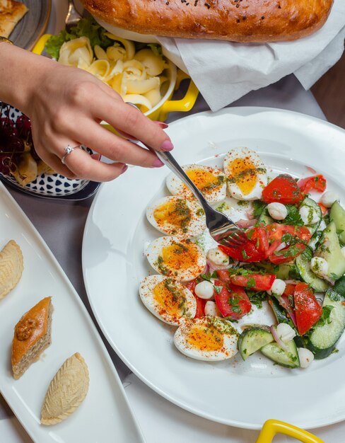 plate of tomato cucumber egg salad, pakhlava, shekerbura for breakfast