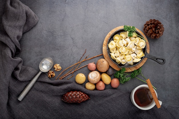 Plate of tortellini and mushrooms on a grey background