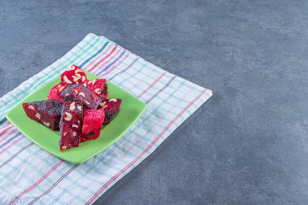 A plate of Turkish delights on a tea towel , on the marble background.