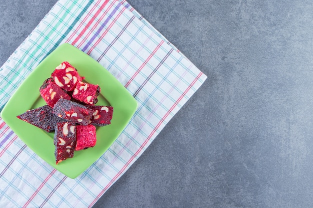 Free photo a plate of turkish delights on a tea towel on the marble surface