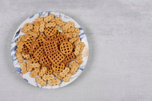 Plate of various salted crackers on stone.