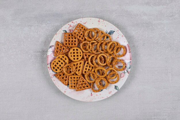 Plate of various salty crackers on stone.