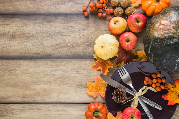 Free photo plate between vegetables and dry leaves