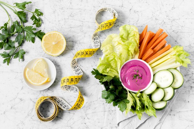 Plate of vegetables with measuring tape and pink sauce