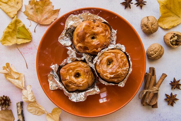 Plate with baked apples on table