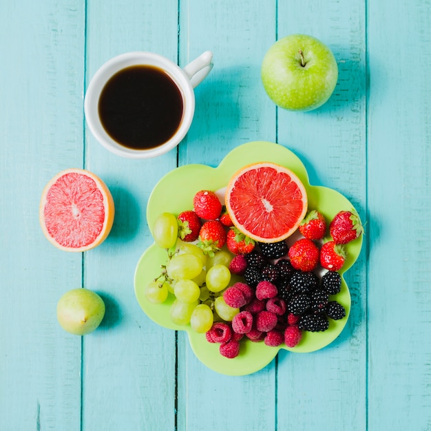 Бесплатное фото Плита с ягодами и чашкой кофе