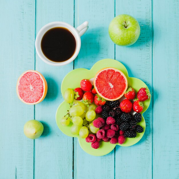 Plate with berries and cup of coffee