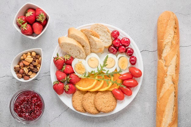 Тарелка с вареными яйцами фруктов и овощей на завтрак