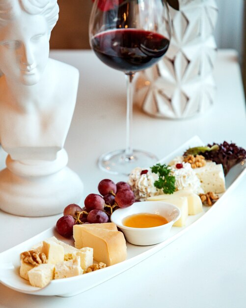 Plate with cheeses and a glass of red wine