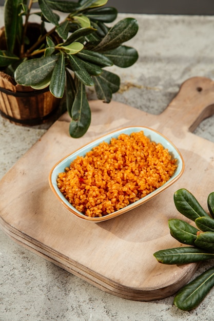 Plate with cooked bulgur on the cutting board