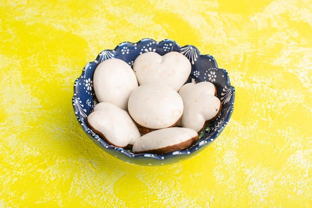 plate with cookies white colred cookies on yellow