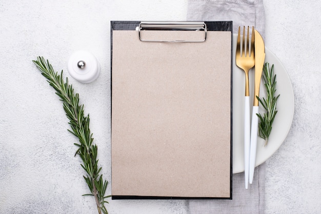 Plate with cutlery and clipboard on top