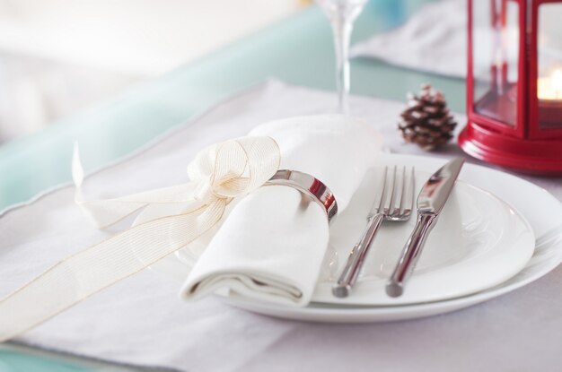 Plate with cutlery well decorated with napkin tied with a golden bow