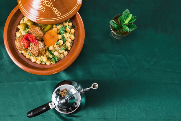 Plate with food near mug of drink and teapot