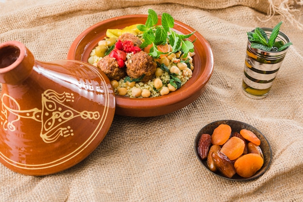 Free photo plate with fresh food near cup and dried fruits on burlap