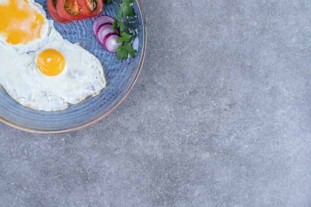 달걀 프라이와 얇게 썬 야채를 곁들인 접시. 고품질 사진