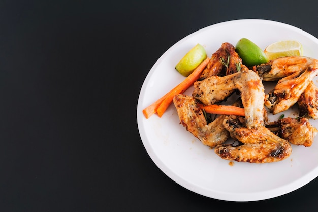 Plate with fried wings and vegetables