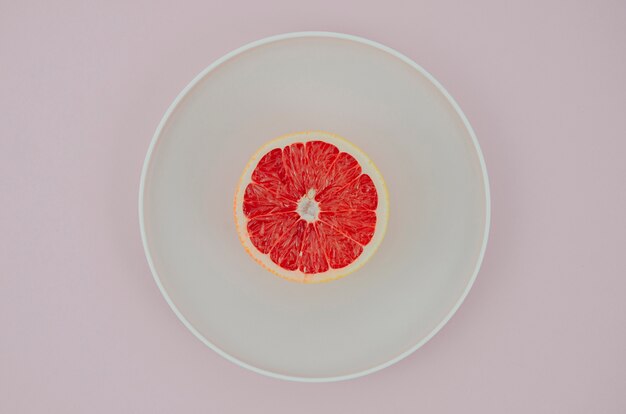 Plate with grapefruit on table