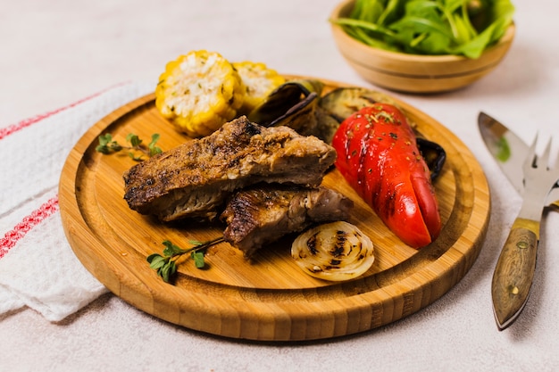 Plate with grilled vegetables and meat on table
