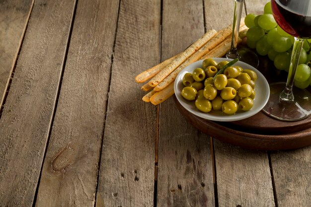 Plate with olives next to a wine glass