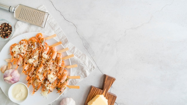 Plate with shrimps skewers on desk