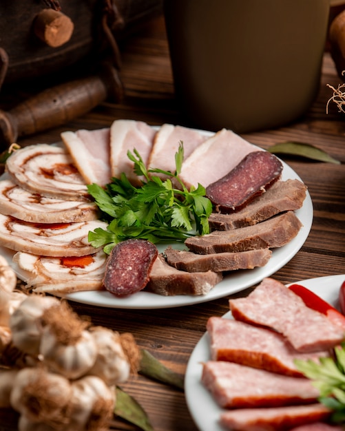 Free photo plate with sliced ham and sausages