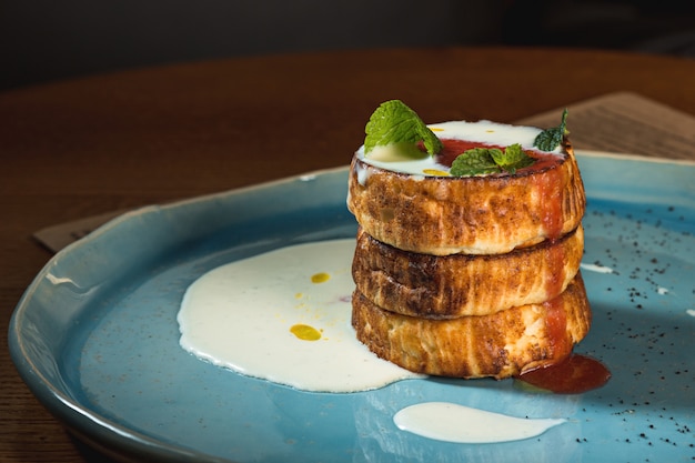 Plate with tasty pancakes on wooden table