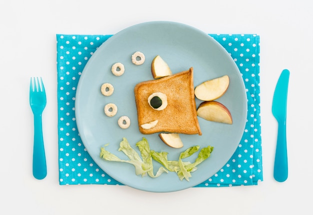 Free photo plate with toast in fish shape with apple on desk