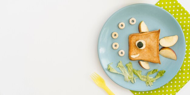 Plate with toast in fish shape with apple with copy-space