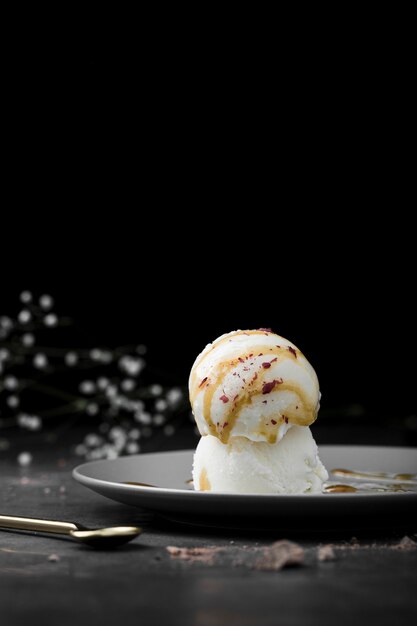 Plate with vanilla ice cream scoops on table