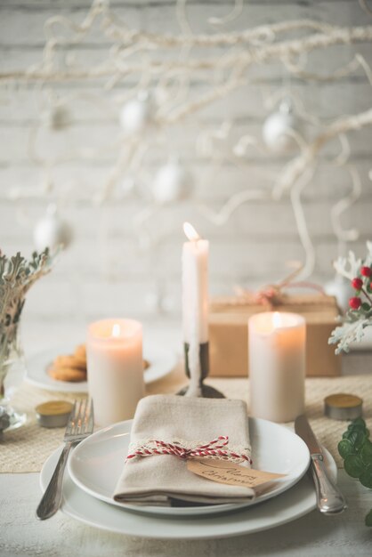 Plates and cutlery set up on table for Christmas dinner