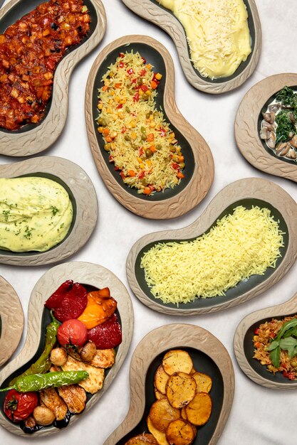 Plates of pilaf mashed potatoes and grilled vegetables